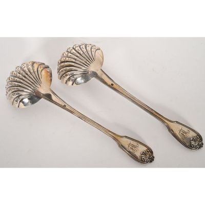 a pair of silverware spoons with shells on them