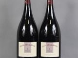 deux bouteilles de vin rouge posées sur une table en verre