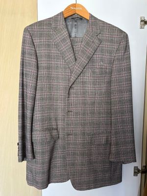 grey and pink checkered jacket hanging on a hanger in front of a door