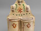 figurine en céramique représentant un homme avec deux tambours posés sur un socle