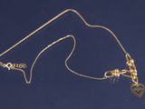 un gros plan sur un collier en or orné d'un cœur