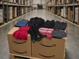 une photo d'un carton rempli de vêtements dans un entrepôt