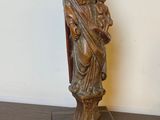 statue en bois représentant une femme tenant un enfant dans ses bras, posée sur une table