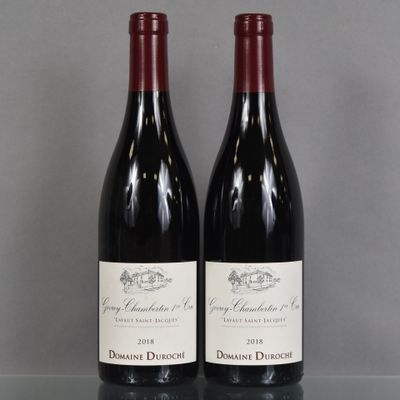 two bottles of red wine sitting on top of a glass table