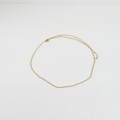 un bracelet en chaîne dorée orné d'un petit pendentif en forme de cœur sur un fond blanc