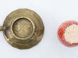 a small cup and saucer sitting next to an apple
