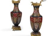 pair of antique vases with decorative designs on stands on a white surface