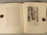 an open book with a picture of a building and a heart on it