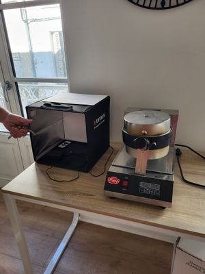 a person standing at a table with a blender on it