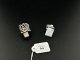 two silver rings and a tag on a black surface
