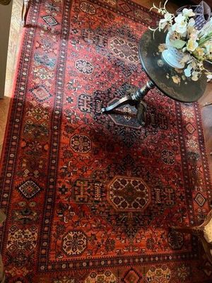 un tapis posé à même le sol, sur lequel est posé un vase de fleurs