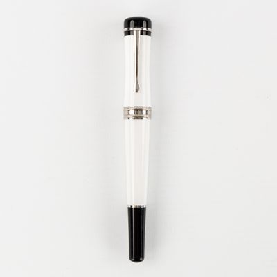un stylo blanc et noir posé sur une surface blanche