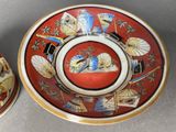 pair of oriental plates with designs on them sitting on a table