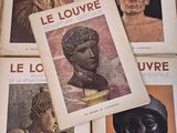 several books with pictures of ancient statues on them sitting on a table