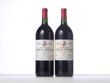 two bottles of red wine sitting on top of a table