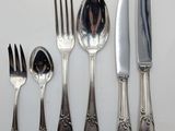 a lot of silver spoons and forks on the table