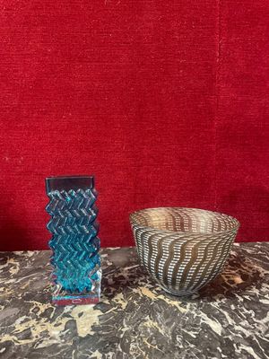 two vases sitting on a table with a red background