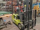 a fork lift truck in a warehouse with a pool table in the background