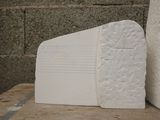 two white bookends sitting on a table next to a brick wall