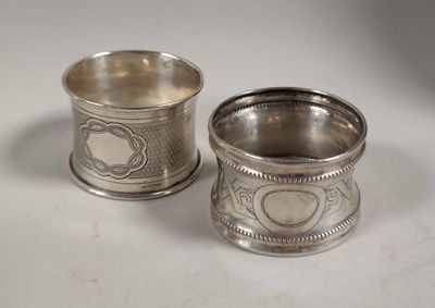 deux tasses en argent ornées de motifs, posées sur une surface blanche