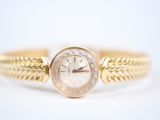 an image of a close up of a watch on a gold bracelet