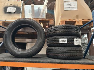 two tires on a shelf in a warehouse with boxes and pallets in the background