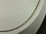 a gold chain that is attached to a white plate