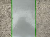 a mirror with a green border on a concrete wall