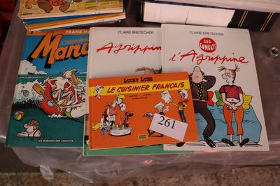 Plusieurs livres pour enfants sont posés sur une boîte en plastique posée par terre.
