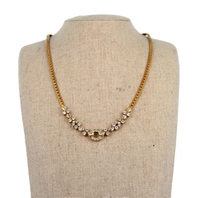 un collier à chaîne en or orné de pierres en cristal sur un mannequin