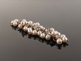 a close up of a white pearl necklace on a black surface
