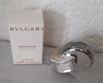 un flacon de Bvlgari posé sur une table, à côté d'un coffret de parfum