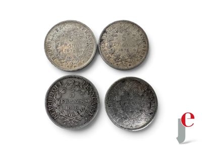 quatre types différents de pièces d'argent sur une surface blanche
