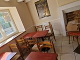 tables and chairs in a room with a fire place in the background