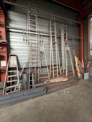de nombreuses échelles posées devant une porte de garage