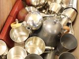 a box full of silver pots and pans on the floor