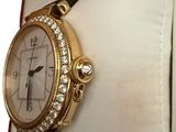 an image of a gold watch with a diamond bezeled face
