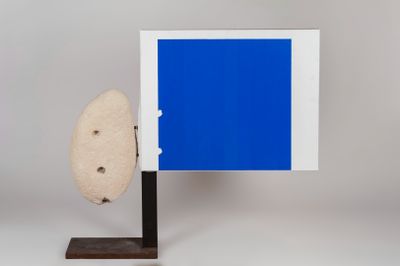 an image of a blue picture frame with a rock on a stand