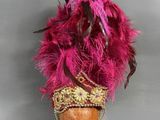 chapeau rose à plumes, orné d'une bordure dorée et de perles, monté sur une coiffe en bois