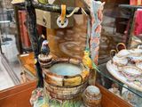 a figurine of a bird drinking water from a fountain