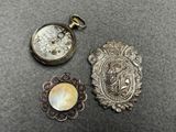 trois bijoux en argent et en nacre posés sur une table