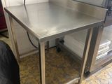 a stainless steel table with a black chair in front of it