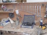 a workbench with tools and a laptop on top of it