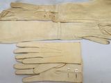two pairs of leather gloves are sitting on a white surface