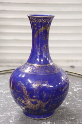 un vase bleu posé sur un plateau, lui-même posé sur une table