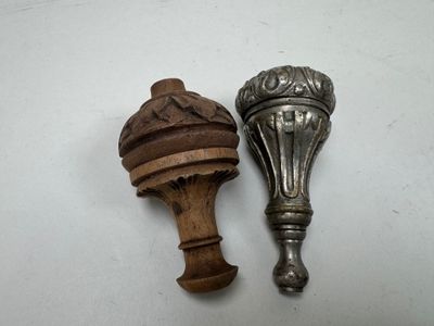deux cuillères anciennes en bois, ornées de motifs élaborés, posées sur un fond blanc
