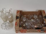 une boîte remplie de vases en verre à côté d'une boîte de vases en verre vides