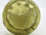 a yellow glass bottle with a gold lid