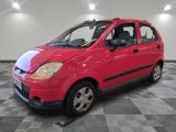 une photo d'une petite voiture rouge posée sur un sol à damier