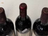 three bottles of wine are lined up on a table